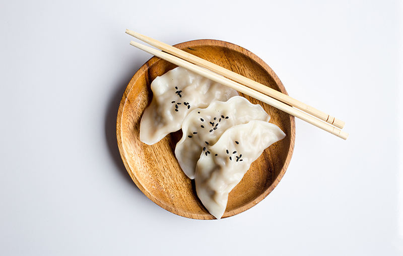 bamboo plate with chinese dumplings and sticks